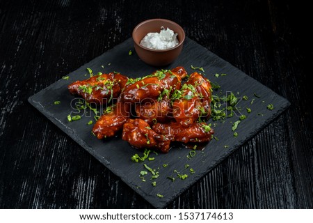 Chicken Wings with tomato barbecue sauce. In a small bowl of horseradish. Diagonal view. Royalty-Free Stock Photo #1537174613