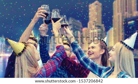 Young people having fun drinking red wine at night party – group of beautiful friends at birthday event  celebrating life outdoor at rooftop restaurant clinking glasses and laughing throwing confetti