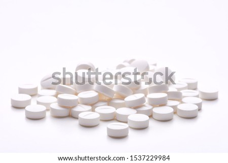 Still life with pile of round pills or tablets, antidepressants or painkillers with space for text. Isolated on white background. Royalty-Free Stock Photo #1537229984