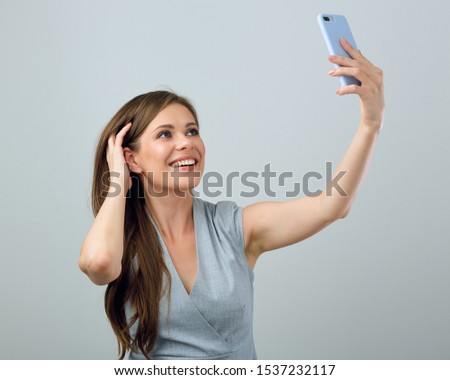 smiling young woman holding smartphon in front of face for selfie. isolated female portrait.