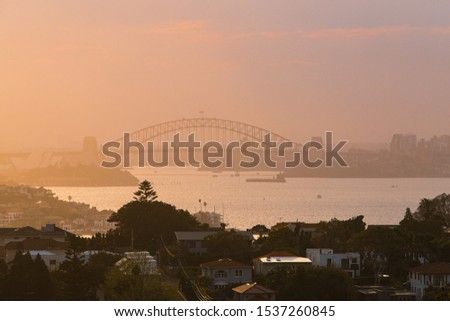 Sydney Harbour Bridge view in a warm foggy sunset.