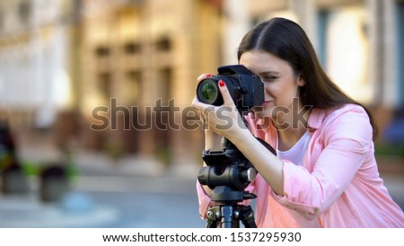 Professional female photographer focusing camera objective, photo shooting