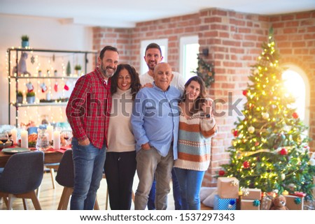 Beautiful family smiling happy and confident. Standing and posing with tree celebrating Christmas at home