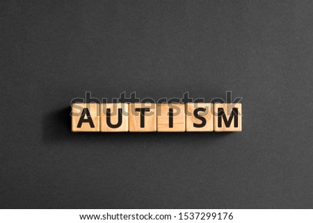 Autism - word from wooden blocks with letters, autism spectrum disorder (ASD) concept,  top view on grey background