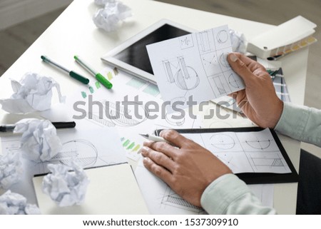 Male designer working at white table, closeup