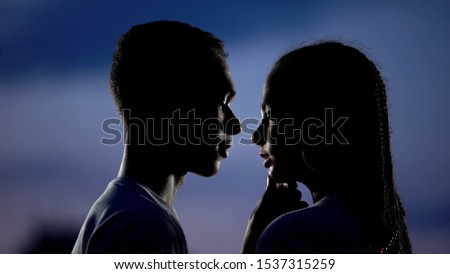 Lovely couple dreaming of romantic kiss in darkness, shy inexperienced teens Royalty-Free Stock Photo #1537315259