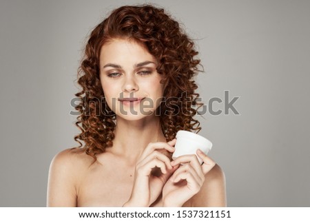 Jar with moisturizing cream lotion hairstyle curls smile woman
