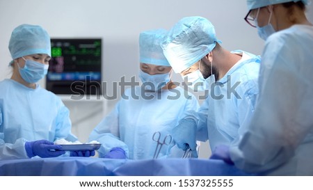 Team of professional surgeons on hospital operation, saving patient life Royalty-Free Stock Photo #1537325555