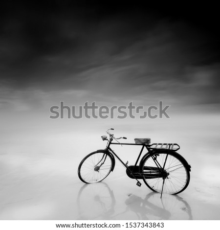 vintage bicycle near the beach during sunrise, black and white photography.
long exposure photography. soft and grain effect