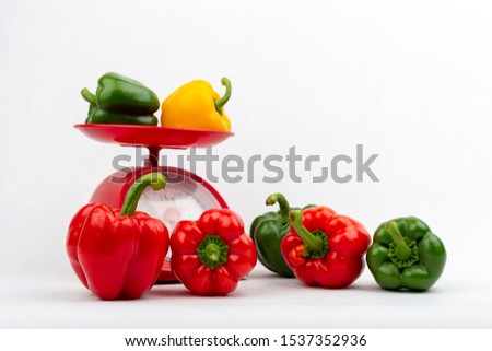 Sweet peppers on red scales market concept on the white background isolated