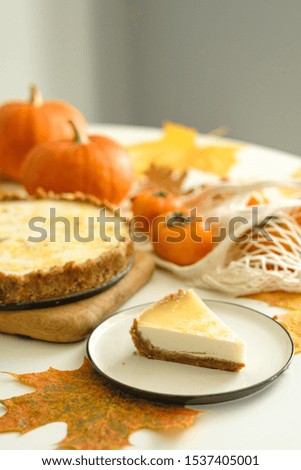 pumpkin cheesecake with persimmon. Autumn composition with leaves, persimmons and pumpkin. Thanksgiving concept. Halloween