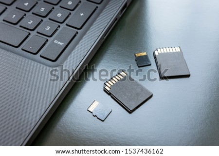Flash drives lie on a table near a laptop