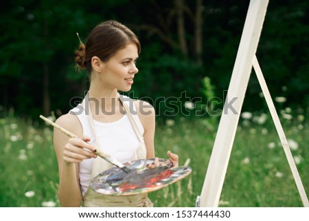 woman young easel in nature draws