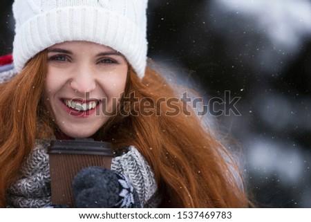 Close up of smiling young woman enjoying coffee or tea on winter day, empty space