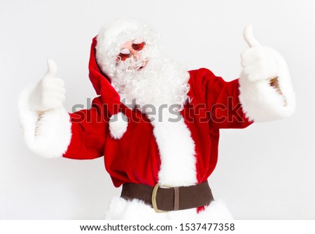 Merry Christmas in warm countries. Modern Santa Claus in sun glasses showing thumbs up on white background