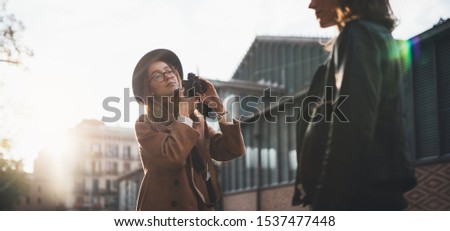 Hobby photographer concept mokup. Outdoor lifestyle portrait of pretty woman having fun in sun city Europe with camera travel photo of photographer in glasses and hat take photo model girlfriends