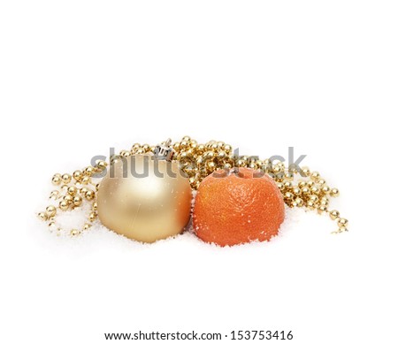 Christmas jewelry and mandarin on snow. Isolated on the white.