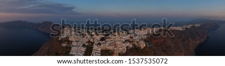 Aerial drone panoramic photo of iconic picturesque village of Imerovigli built on top of steep hill with amazing views to Caldera and Santorini island, Cyclades, Greece
