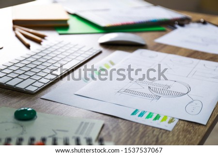 Sheets of paper with sketches on wooden table. Designer's workplace