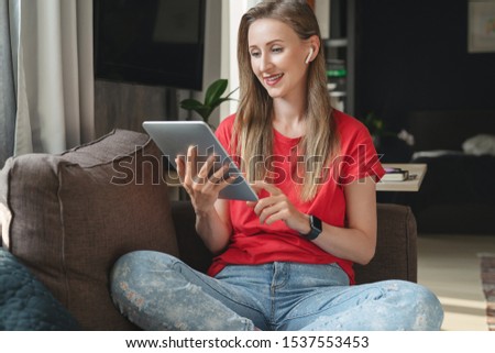 Female freelance worker doing projects on mobile connected gadgets. Girl typing on tablet and surfing internet. Useful apps for work and education, creative features, editing, taking pictures, videos.
