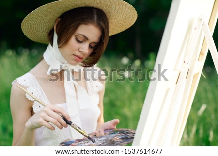 woman young model in a beautiful summer dress on an easel glade