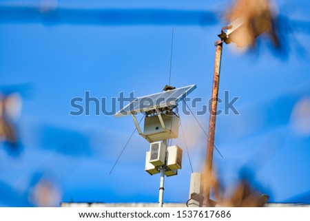 Solar battery and radio antenna on the post.