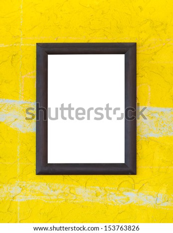 Wooden photo frame on yellow wall
