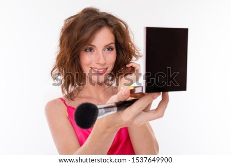 portrait of a charming brunette with cosmetics in her hands on a white background, beauty industry blogger