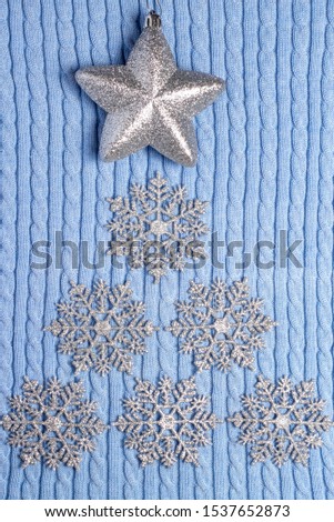star and snowflakes in the shape of a Christmas tree on a winter blue background