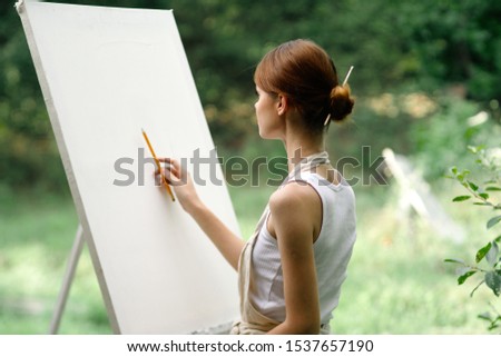 woman young easel paints a picture model