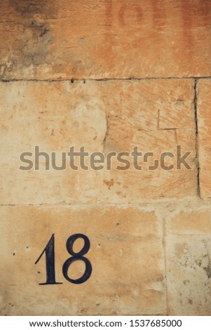 Number eighteen on a brown wall