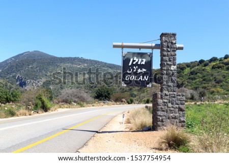 Sign with lettering "Golan" in Hebrew, Arabic and English on street towards Golan Heights in Israel Royalty-Free Stock Photo #1537754954