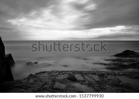 Seascape View from atlantic ocean coastline, black and white long exposure dramatic picture.