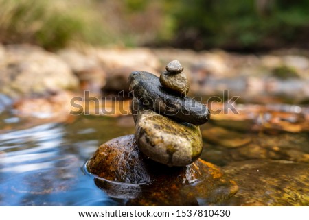 Stones arranged in zen towers by the river bed on a summers day