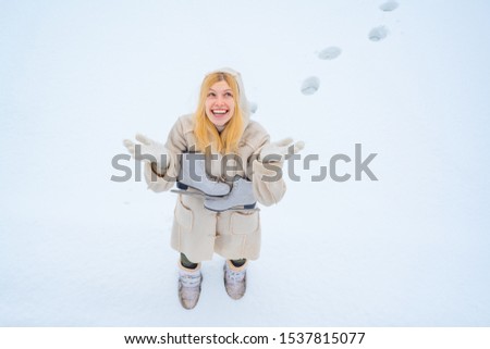 Outdoor winter activities on weekends in cold weather. Winter funny woman with ice-skating. Beauty Joyful Model Girl laughing and having fun in winter park