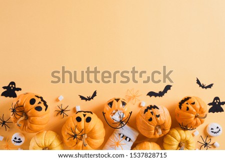 Top view of Halloween crafts, orange pumpkin, white ghost, bat and spider on orange background with copy space for text. halloween concept.