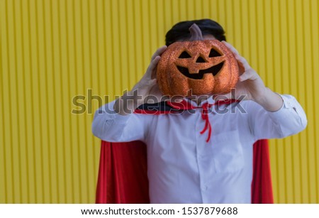 Man holding orange pumpkins on Halloween night