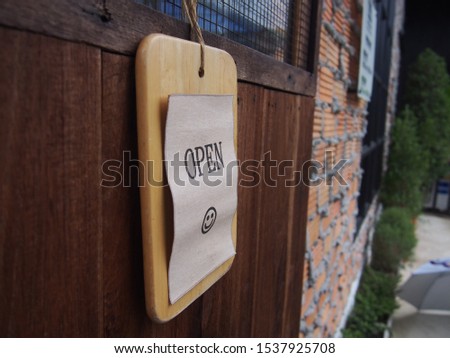  Open vintage wooden sign board hanging on door of cafe.