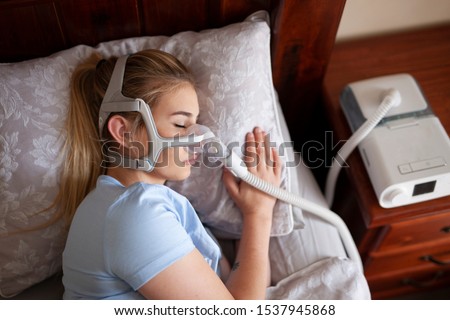 Young female sleeping with cpap machine for sleep apnea  Royalty-Free Stock Photo #1537945868