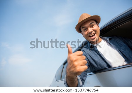 Asian men wear hats The blue shirt is driving and thumbs up This picture is about Travel by car, car insurance, and buying and selling cars