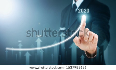 Man standing and pointing hand with Arrow and Line Visual Graphic on Light of Len flare and Boke blue background. COPY SPACE. Business Concept : Market Uptrend and Forecast 2020