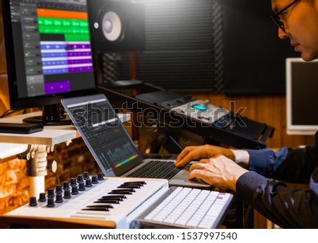 male producer, musician, composer making a song in home recording studio. music production concept
