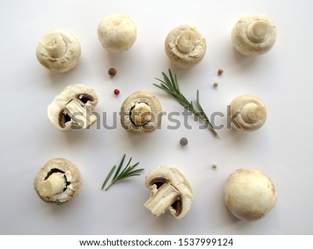 Mushroom background. Fresh brown champignon mushrooms, pepper seeds and fresh rosemary on white background, flat lay. Royalty-Free Stock Photo #1537999124