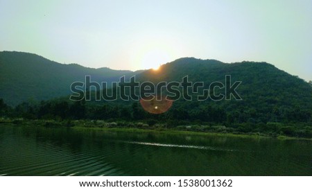 Sunset in mountains behind the river