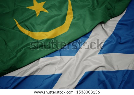 waving colorful flag of scotland and national flag of mauritania. macro