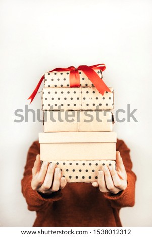 Closeup stack of boxes in female hands. A face of person is not visible. Vertical image