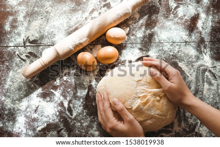 Making dough by female hands on wooden table background. Cooking concept. Lovely female hands.