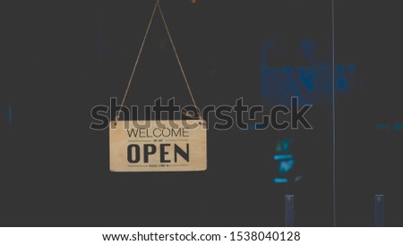 Wooden sign board hanging on door of cafe restaurant .Open vintage sign broad through the glass of store window.commercial business background for advertisement 