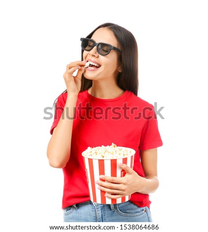 Young woman eating popcorn on white background