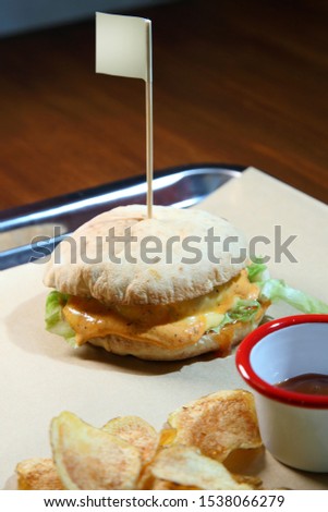Burger with meat and vegetables. Hot burger in a burning sauce. Double cheese burger.